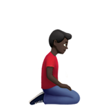 klęczący mężczyzna: karnacja ciemna i zwrócony w prawo